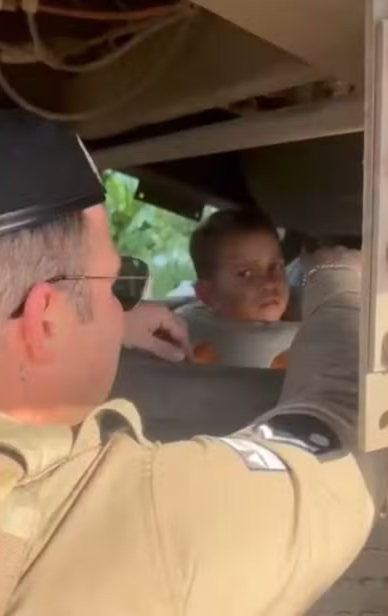 Um menino de 4 anos foi resgatado por policiais militares ap&oacute;s prender a cabe&ccedil;a na roda estepe de uma carreta. | Foto: Redes Sociais